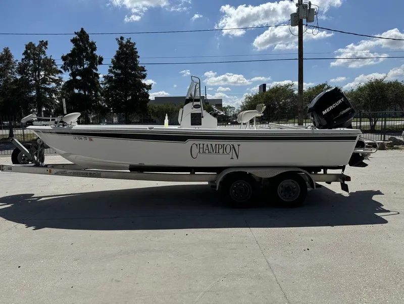 Slide: The Image of 2007 Champion 220 Bay boat on trailer, outdoors, with Mercury outboard motor. - 2