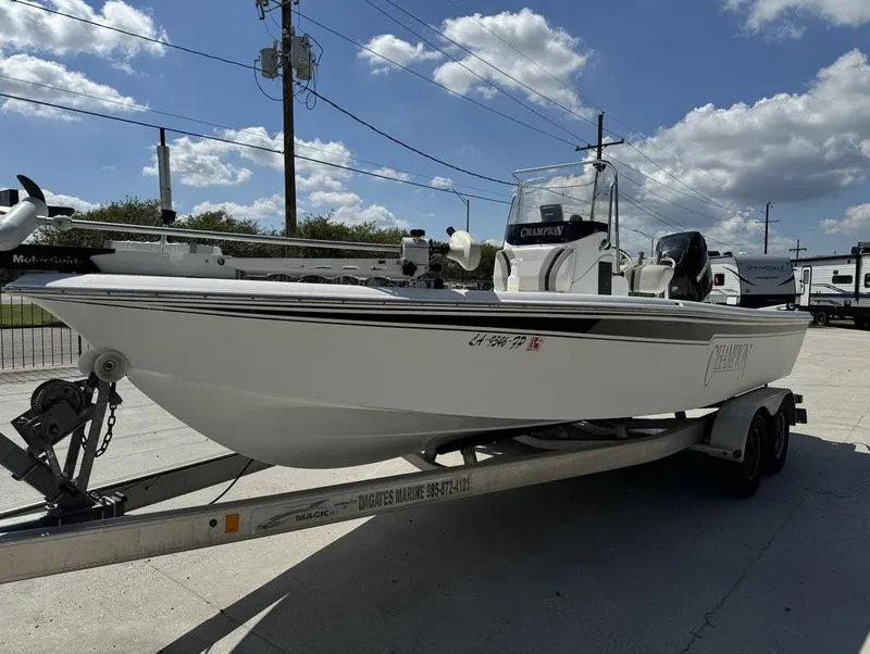 Slide: The Image of 2007 Champion 220 Bay boat on trailer under a clear blue sky. - 3