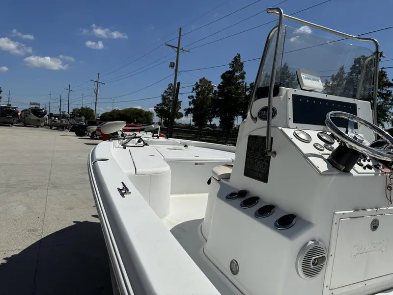 Slide: The Image of 2007 Champion 220 Bay boat with console and steering wheel, parked outdoors. - 7
