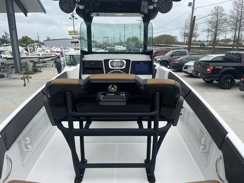Slide: The Image of 2022 Scarab 255 Open ID boat interior with helm and seating, parked at a dealership. - 5