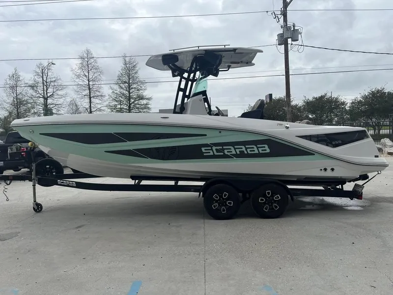 Slide: The Image of 2022 Scarab 255 Open ID boat on trailer, parked outdoors. - 9