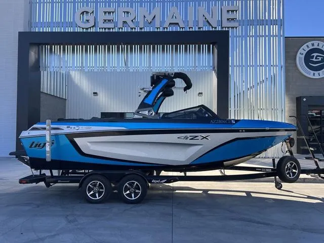 Slide: The Image of 2020 Tigé 23ZX boat in blue and white on a trailer at Germaine dealership. - 1