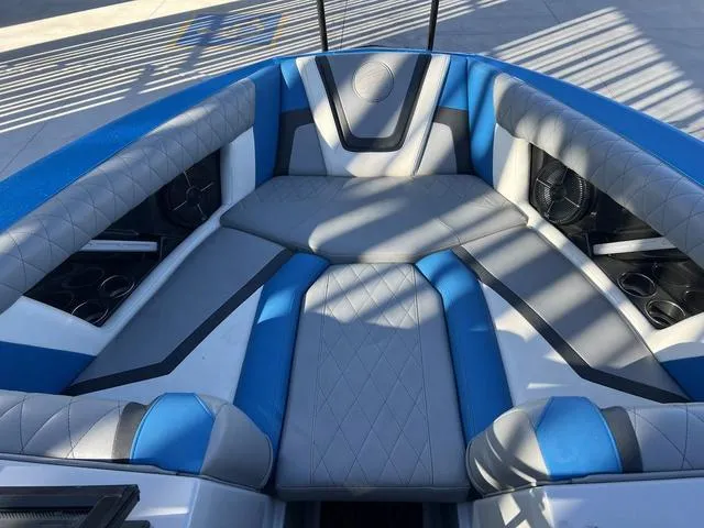 Slide: The Image of 2020 Tigé 23ZX boat interior with blue and gray seating, cup holders, and speakers. - 10