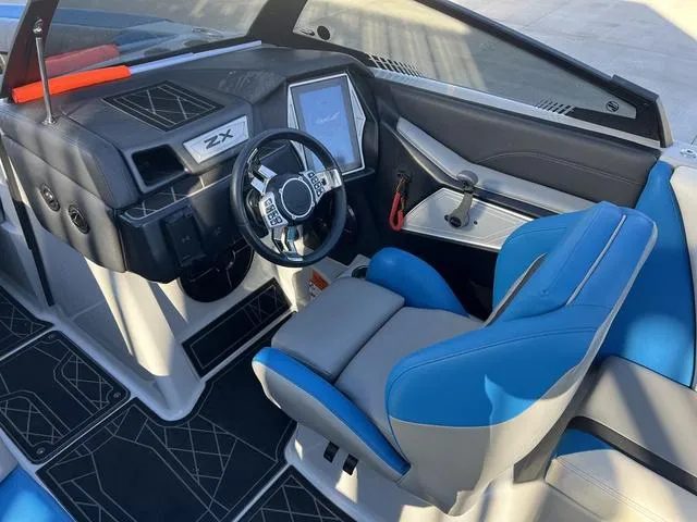 Slide: The Image of 2020 Tigé 23ZX boat interior with blue seats and modern dashboard. - 11