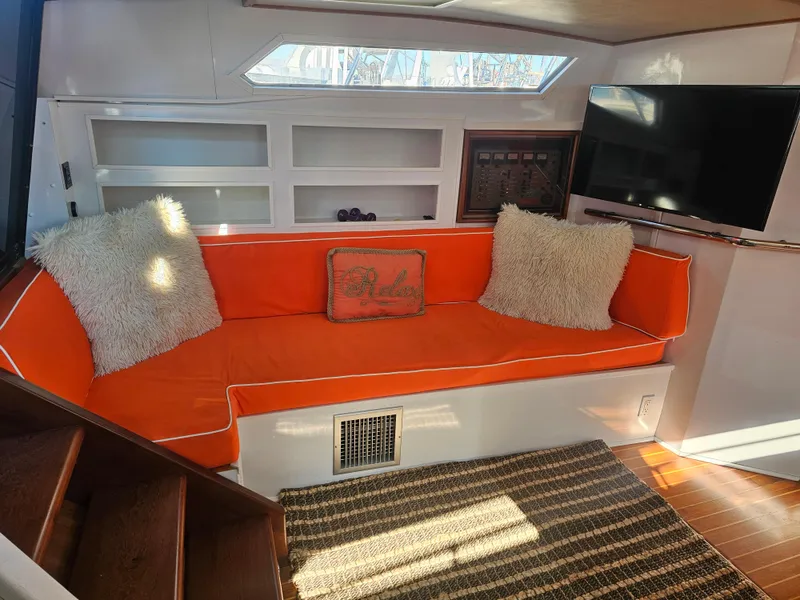 Slide: The Image of Interior of 1988 Sea Ray 390 Express Cruiser with orange seating and modern decor. - 10