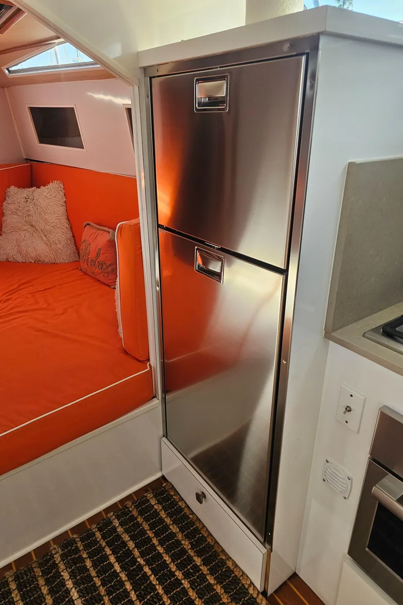 Slide: The Image of 1988 Sea Ray 390 Express Cruiser interior with stainless steel fridge and orange seating. - 12