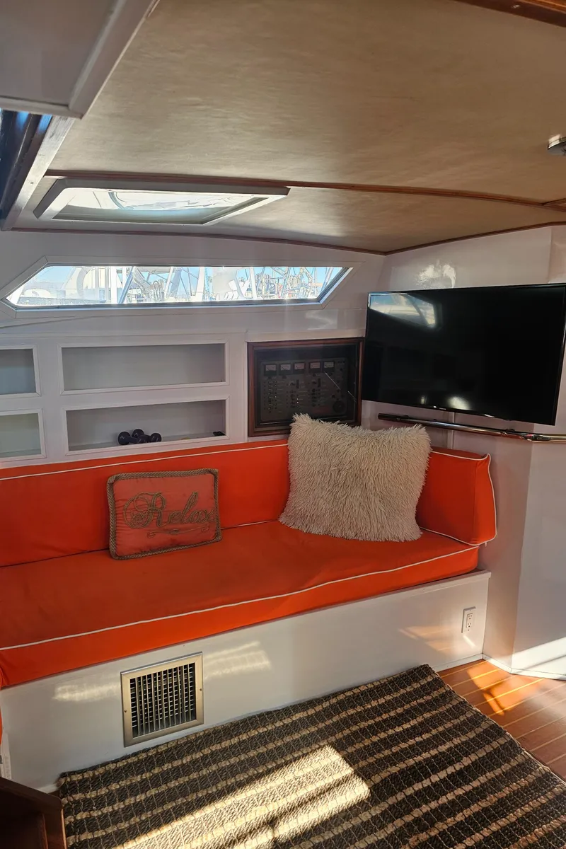 Slide: The Image of Interior of 1988 Sea Ray 390 Express Cruiser with orange seating and a wall-mounted TV. - 13