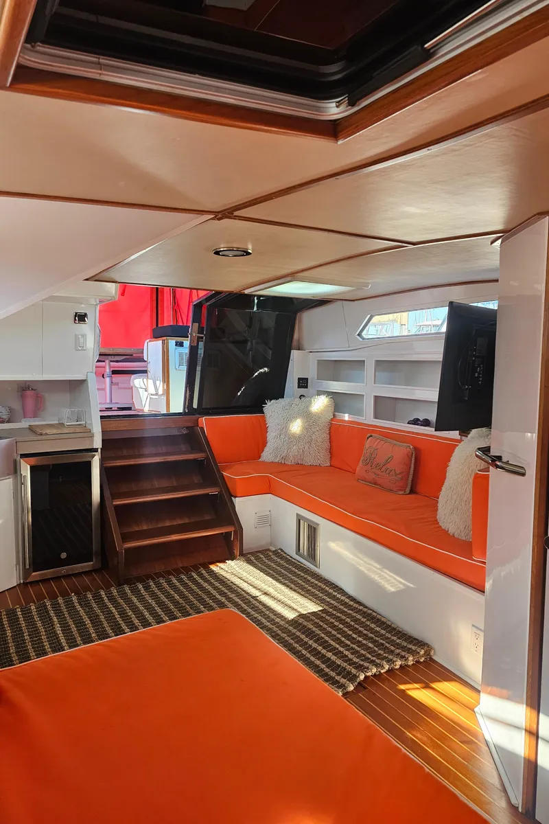 Slide: The Image of Interior of 1988 Sea Ray 390 Express Cruiser with orange seating and wooden accents. - 14