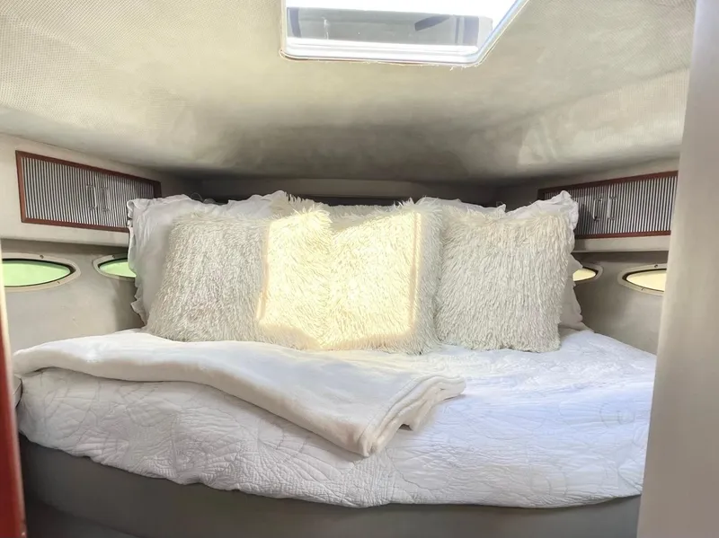 Slide: The Image of Cozy cabin interior of 1988 Sea Ray 390 Express Cruiser with plush bedding. - 15