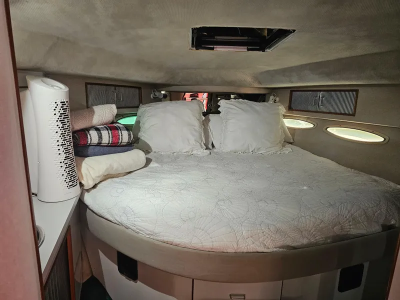 Slide: The Image of Cozy cabin interior of 1988 Sea Ray 390 Express Cruiser with bed and storage. - 16