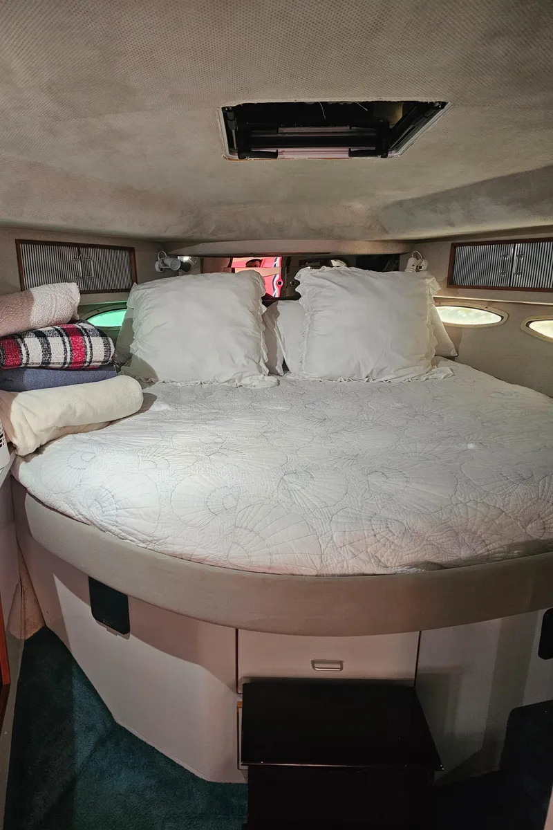 Slide: The Image of 1988 Sea Ray 390 Express Cruiser cabin with cozy bed and pillows. - 17