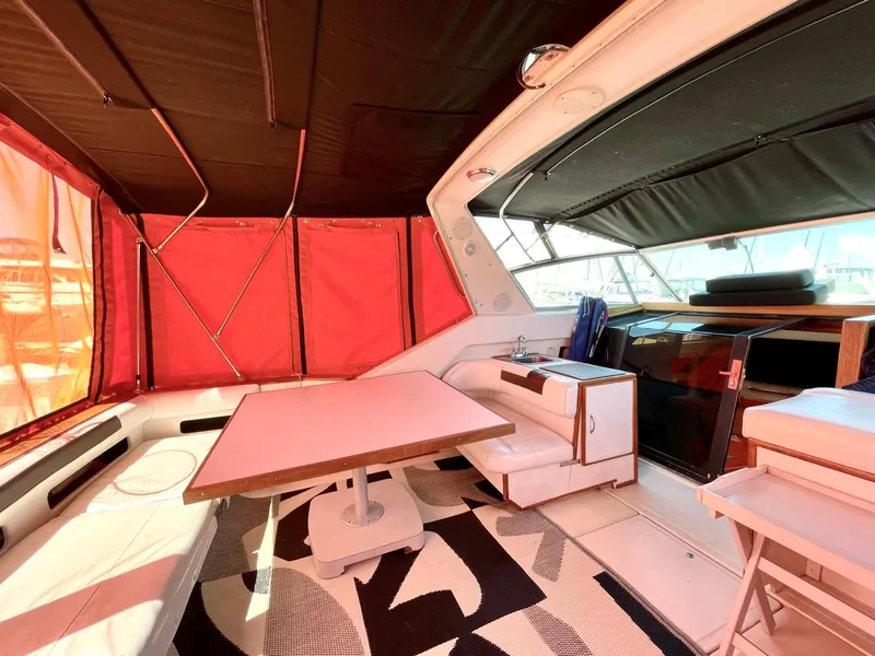 Slide: The Image of 1988 Sea Ray 390 Express Cruiser interior with red canopy and seating area. - 18