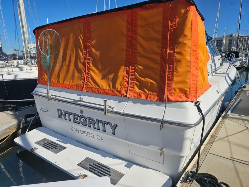 Slide: The Image of 1988 Sea Ray 390 Express Cruiser docked, featuring orange canopy and "Integrity" name. - 19