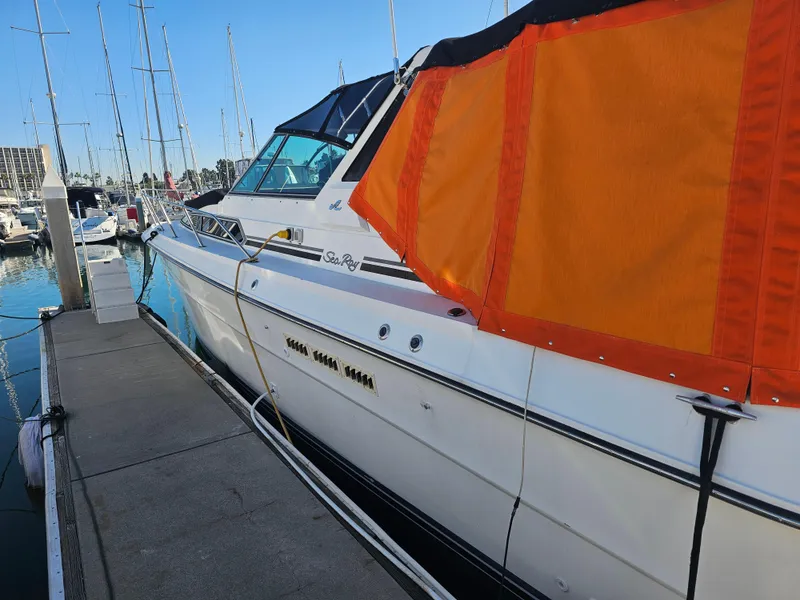 Slide: The Image of 1988 Sea Ray 390 Express Cruiser docked at marina with orange cover. - 21