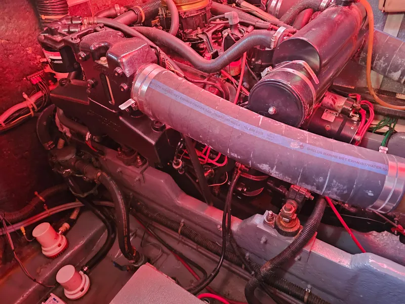 Slide: The Image of Engine compartment of a 1988 Sea Ray 390 Express Cruiser with visible hoses and components. - 27