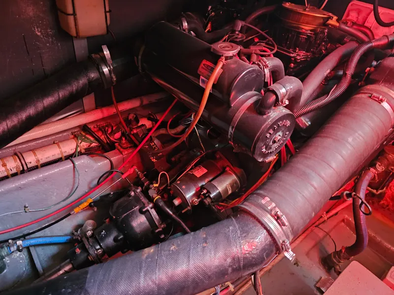 Slide: The Image of Engine compartment of a 1988 Sea Ray 390 Express Cruiser with visible hoses and wiring. - 28