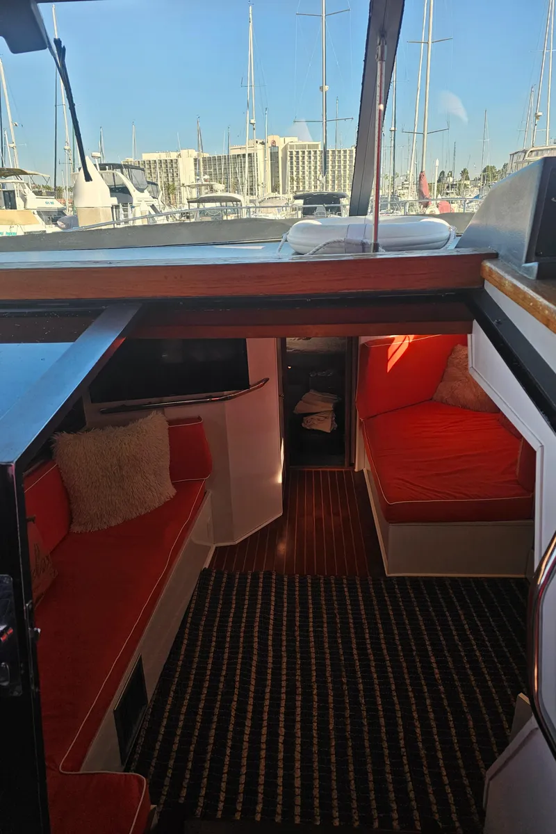 Slide: The Image of Interior of 1988 Sea Ray 390 Express Cruiser with red seating and marina view. - 6