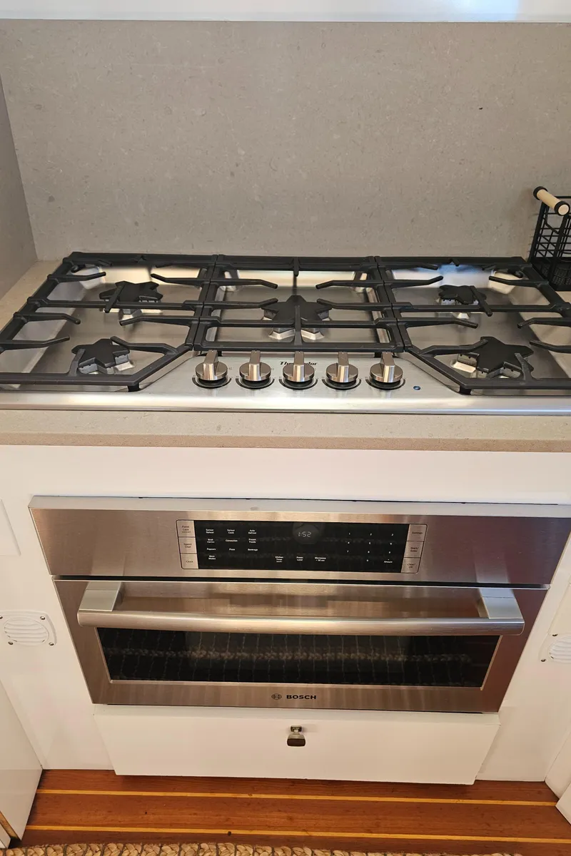 Slide: The Image of Stainless steel gas stove and oven in a modern kitchen setting. - 9