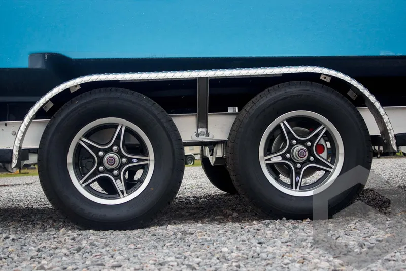 Slide: The Image of Trailer wheels of 2025 Tidewater 2500 Carolina Bay boat on gravel. - 13