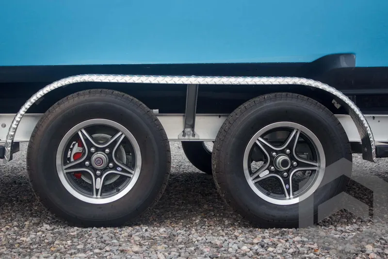 Slide: The Image of Trailer wheels of 2025 Tidewater 2500 Carolina Bay boat on gravel. - 18
