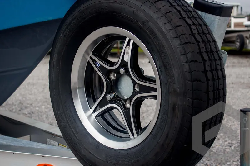 Slide: The Image of Trailer wheel of 2025 Tidewater 2500 Carolina Bay boat on gravel surface. - 20