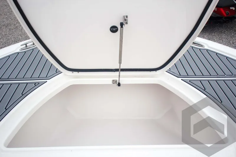 Slide: The Image of 2025 Tidewater 2500 Carolina Bay storage compartment with open lid and non-slip deck. - 29