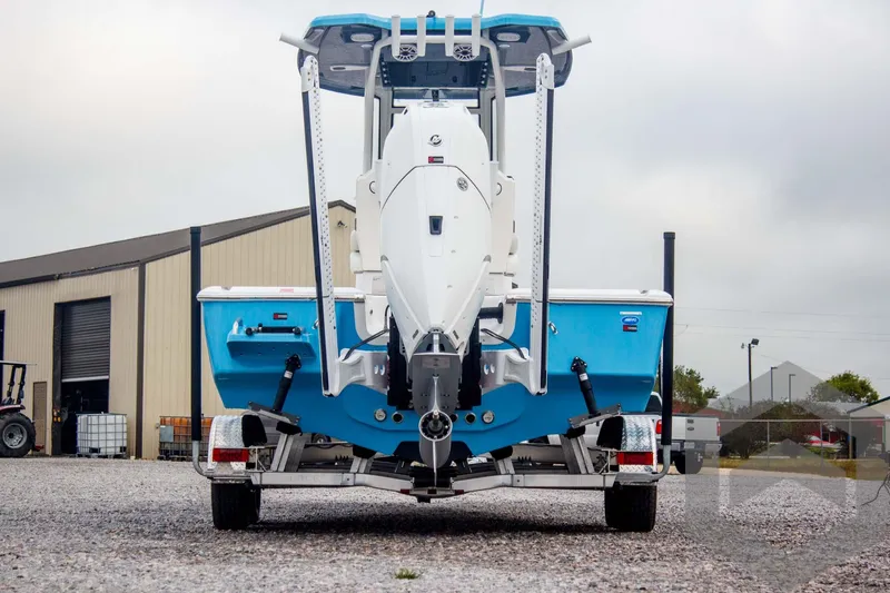 Slide: The Image of 2025 Tidewater 2500 Carolina Bay boat on trailer, rear view, blue and white design. - 5