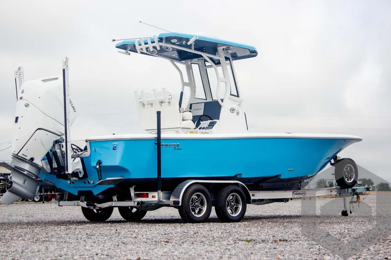 Slide: The Image of 2025 Tidewater 2500 Carolina Bay boat on trailer, vibrant blue hull, dual engines. - 6
