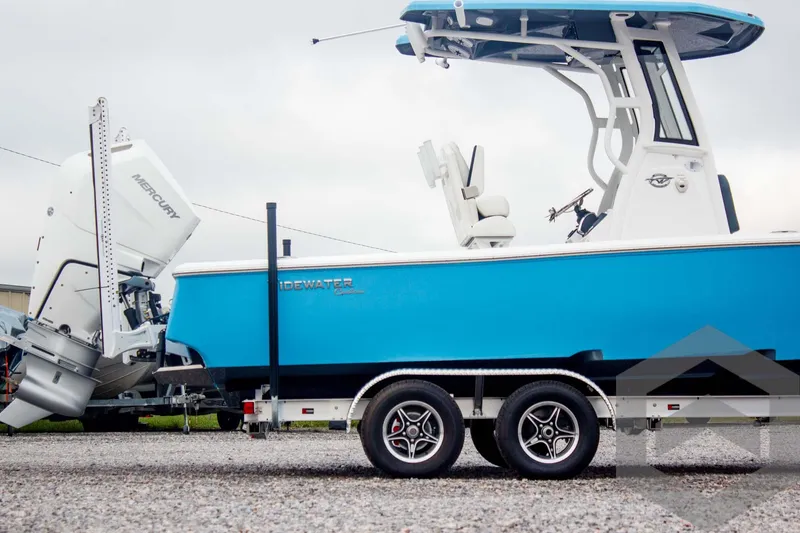 Slide: The Image of 2025 Tidewater 2500 Carolina Bay boat on trailer, featuring blue hull and Mercury outboard engine. - 7
