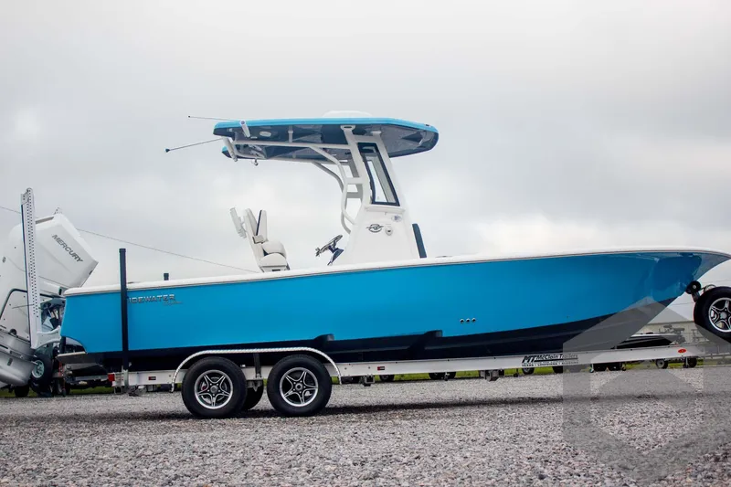 Slide: The Image of 2025 Tidewater 2500 Carolina Bay boat on trailer, vibrant blue hull, overcast sky. - 8