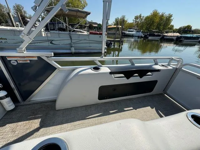 Slide: The Image of 2021 Tahoe LTZ Versatile Rear Lounger 24' pontoon boat interior, docked by a serene lake. - 9