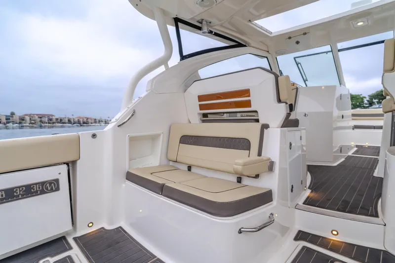 Slide: The Image of 2018 Pursuit 365 DC boat interior with cushioned seating and sleek design. - 13