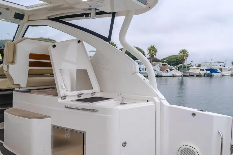 Slide: The Image of 2018 Pursuit 365 DC boat interior with kitchenette, docked at marina. - 15