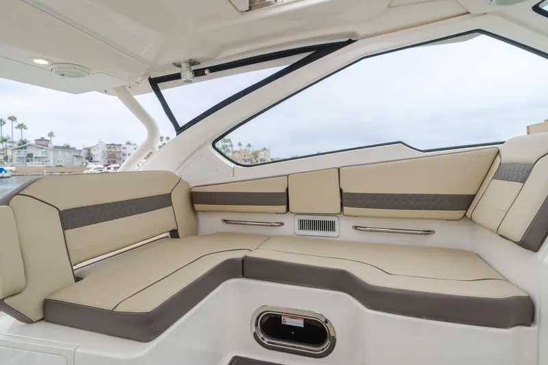 Slide: The Image of Luxurious interior seating of 2018 Pursuit 365 DC boat, featuring beige and brown upholstery. - 16