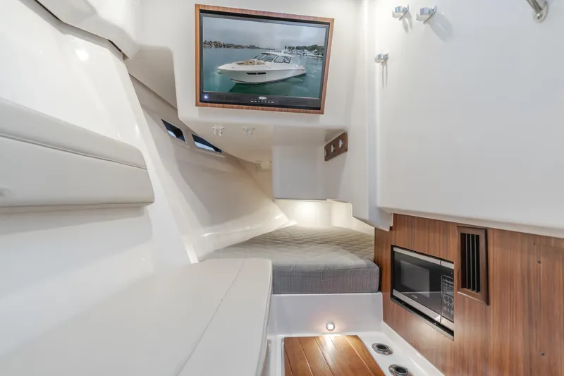 Slide: The Image of Interior cabin of 2018 Pursuit 365 DC boat with modern amenities and wood accents. - 22