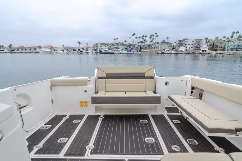 Slide: The Image of 2018 Pursuit 365 DC boat interior with seating, overlooking a marina. - 34