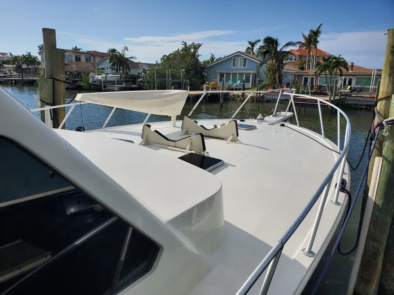 Slide: The Image of 1988 Post 46 Sportfish yacht docked in a scenic waterfront setting. - 4