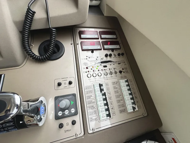 Slide: The Image of Control panel of a 2014 Ferretti Yachts 530, featuring various switches and displays. - 23