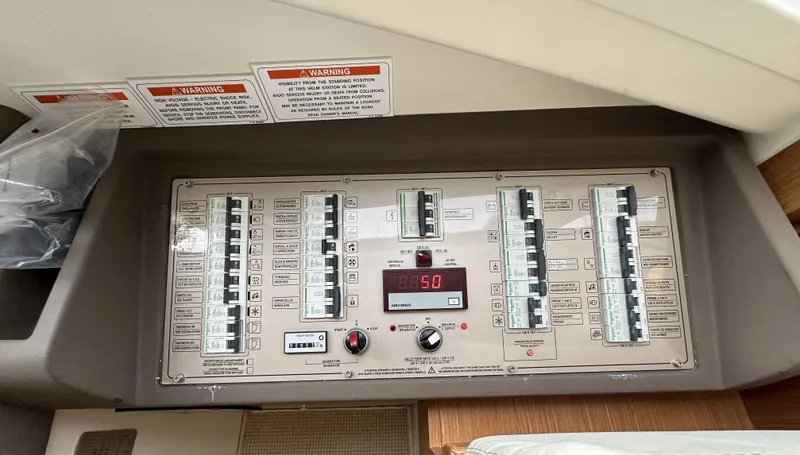 Slide: The Image of Control panel of a 2014 Ferretti Yachts 530, featuring switches and warning labels. - 24