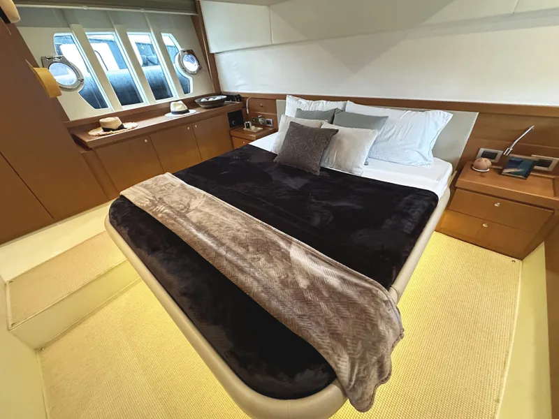 Slide: The Image of Luxurious bedroom interior of 2014 Ferretti Yachts 530 with elegant bedding and porthole windows. - 28