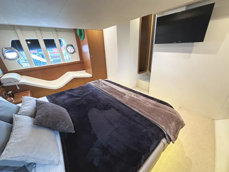 Slide: The Image of Luxurious bedroom interior of 2014 Ferretti Yachts 530 with modern decor and porthole windows. - 31