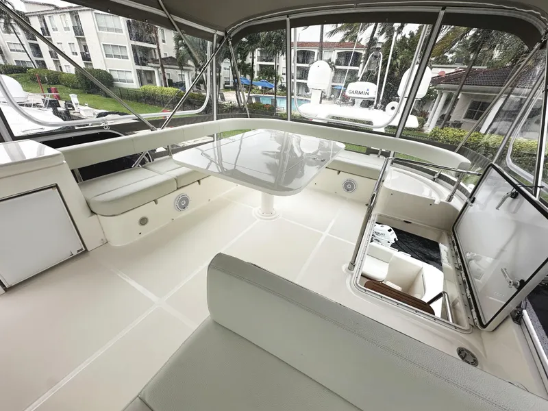 Slide: The Image of 2014 Ferretti Yachts 530 flybridge with seating and table, docked near waterfront buildings. - 50
