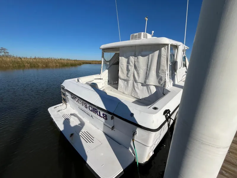 Slide: The Image of 1987 Sea Ray 460 boat docked on calm water under clear blue sky. - 3