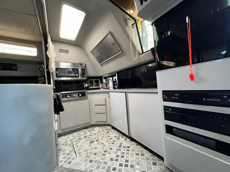 Slide: The Image of Interior of 1987 Sea Ray 460 yacht, featuring modern kitchen appliances and sleek cabinetry. - 34