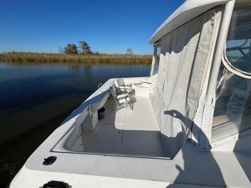 Slide: The Image of 1987 Sea Ray 460 boat on calm water, featuring spacious deck and clear skies. - 4