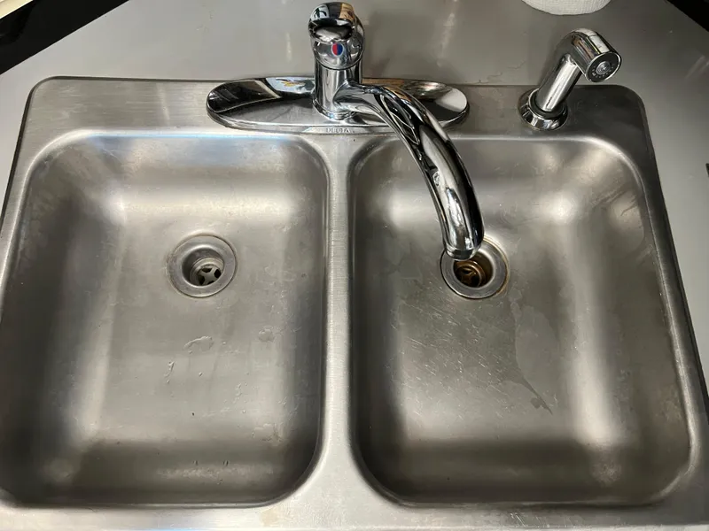 Slide: The Image of Stainless steel double sink with faucet on a 1987 Sea Ray 460 boat. - 44
