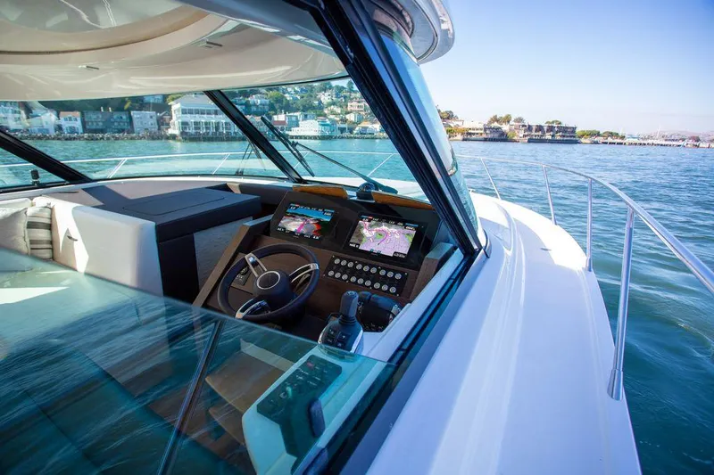 Slide: The Image of 2018 Tiara Yachts C44 Coupe helm with navigation screens on open water. - 17