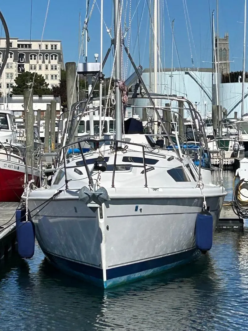 Slide: The Image of 2001 Hunter 320 sailboat docked in a marina, surrounded by other boats. - 2
