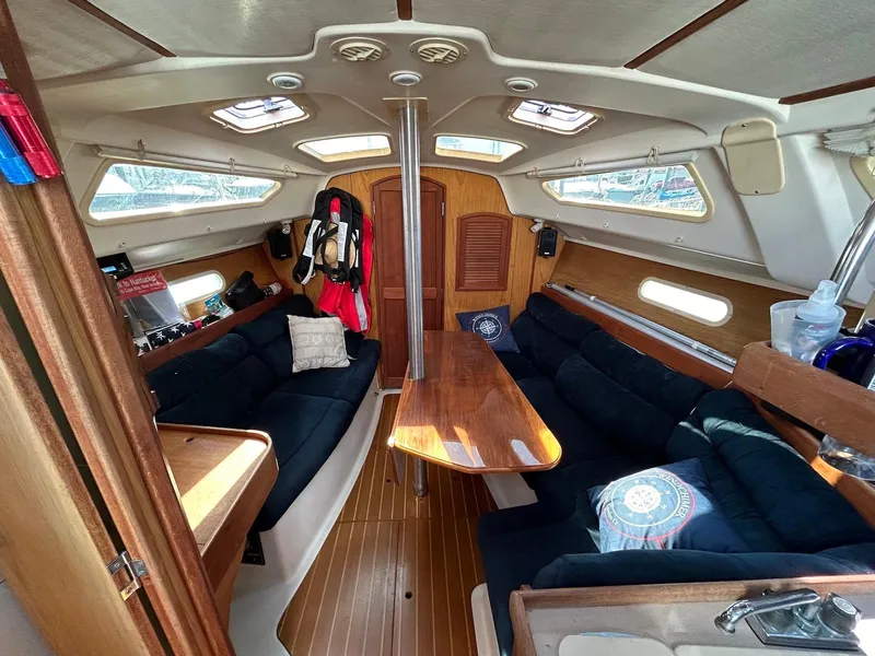 Slide: The Image of Interior of 2001 Hunter 320 sailboat with cozy seating and wooden finishes. - 3