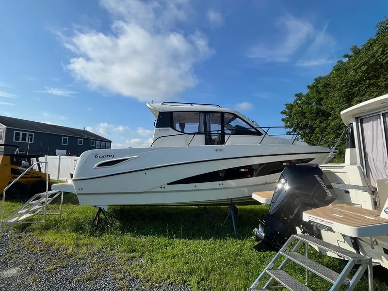The Image of 2025 Bayliner Trophy T29 Explorer boat on display under a clear blue sky. - 1
